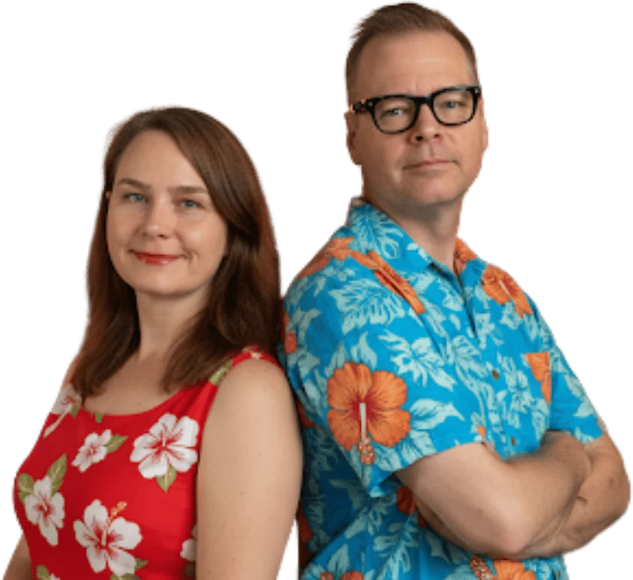 Jennifer and Dan, the hosts of Hawaii Travel Podcast, standing back to back in Hawaiian prints